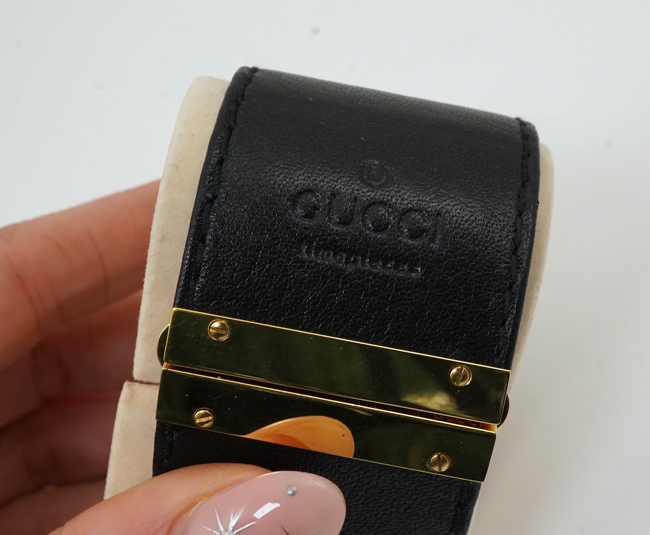 A lady's Gucci watch with wide leather strap, with box and papers.